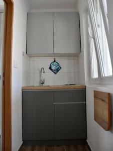 a small kitchen with a sink and a window at Seaside holiday house Cove Krlic, Pag - 23435 in Novalja