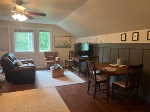 a living room with a table and a tv at Snowgoose Pond Bed & Breakfast in Palmer