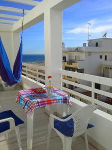 a table and chairs on a balcony with a view of the ocean at Charming with Sea View in Monte Gordo