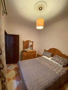 - une chambre avec un lit avec une couette bleue et une lumière dans l'établissement Martil résidence, à Martil