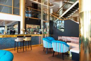 a restaurant with blue chairs and a bar at Thon Hotel Opera in Oslo