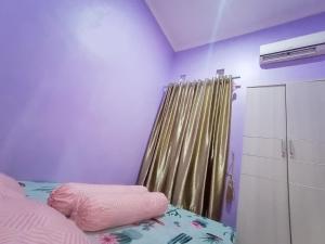 マゲランにあるSeluruh Rumah Karyakita Homestay Magelangのベッドルーム1室(カーテン付きのベッド1台、ベッドサイドサイドサイドサイドサイドサイド付)