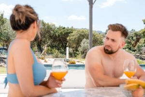 a man and a woman sitting at a table with wine glasses at Casas de Marvão - Quinta da Bela Vista in Marvão