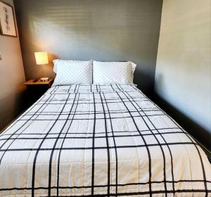 ein Schlafzimmer mit einem Bett mit einer schwarzen und weißen Decke in der Unterkunft Blue Door House in Lakeland
