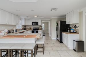 a kitchen with white cabinets and a black refrigerator at Lake Hollingsworth House of Music in Lakeland