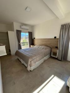 a bedroom with a large bed and a window at Cabañas Balcón del Famatina in Chilecito