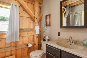 a bathroom with a toilet and a sink and a mirror at The Rustic Retreat in Pearl City