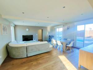a living room with a large couch and a table at La villa de Julien avec piscine in Aureilhan