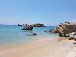 a sandy beach with rocks in the water at Ninizam Kemaman Cukai Homestay in Cukai