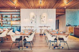 uma sala de jantar com tectos e mesas e cadeiras de madeira em South Congress Hotel em Austin