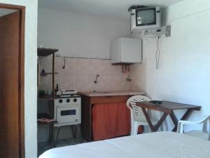 Una pequeña cocina con una mesa y un televisor en la pared. en La Casa del Caminante, en Aguas Dulces 29 fotos más