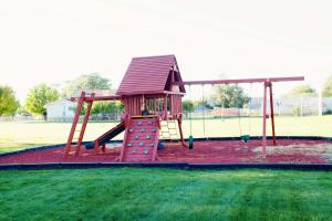 a playground with a slide and a swing at Bryce Canyon Villas in Cannonville