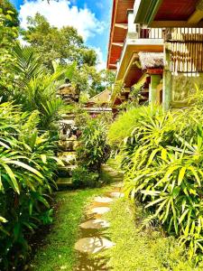 a path in a garden next to a building at The Madawa Suites in Ubud +7 photos