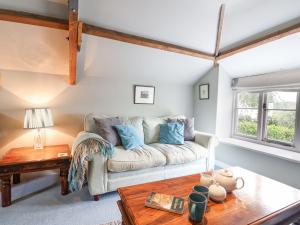 ein Wohnzimmer mit Sofa und Tisch in der Unterkunft Upside Down Cottage in Colyton