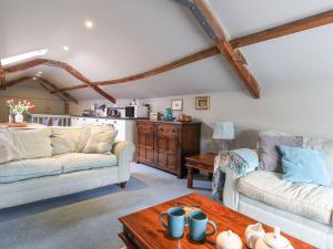 ein Wohnzimmer mit zwei Sofas und einem Tisch in der Unterkunft Upside Down Cottage in Colyton
