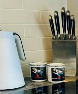 a counter with two canisters and a container of knives at First Tracks Studio in Thredbo