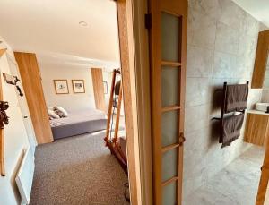 a room with a bedroom with a bed and a doorway at First Tracks Studio in Thredbo