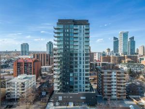 un edificio alto de cristal en una ciudad con edificios en Studio Just Steps from Stampede Park, Luxury Living, en Calgary