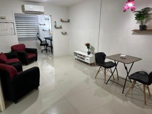 sala de estar con sillas, mesa y mesa en Futura Homes Mactan, en Lapu Lapu City 4 fotos más
