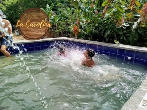 two children are playing in a swimming pool at Cabaña La Carolina in Ibagué