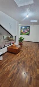 a living room with a wooden floor and a couch at Hostal María - Otavalo in Otavalo