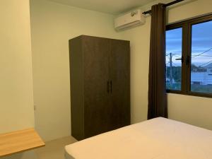a bedroom with a bed and a cabinet and a window at LuxNar FF Sea in La Gaulette