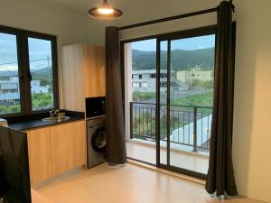 a kitchen with a large glass door with a balcony at LuxNar FF Sea in La Gaulette