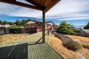 a wooden deck with a house in the background at River Retreat - Lake Tekapo in Lake Tekapo