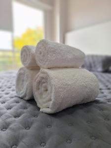 a stack of towels sitting on a bed at Departamentos Güemes in San Fernando del Valle de Catamarca