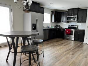een keuken met een tafel, stoelen en een koelkast bij Peaceful room in new house in Raleigh Downtown Area in Raleigh