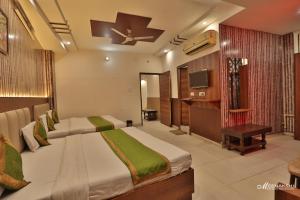 a hotel room with two beds and a television at Hotel Haridev in Roorkee