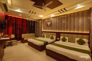 a hotel room with two beds and a desk at Hotel Haridev in Roorkee