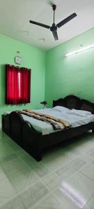 Una cama grande en una habitación con una cortina roja. en Nithilagam Temple and Mountain View Home, en Tiruvannāmalai