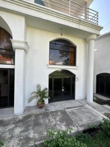 a white house with a potted plant in front of it at Casa Camelina in Cuernavaca