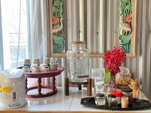 a table with a jar and a vase on it at Retro At Phra Sing Guest House in Chiang Mai