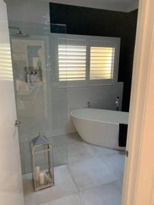 a bathroom with a bath tub and a shower at The Small House - Mid century gem in wine county's Healesville in Healesville +18 photos