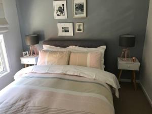 a bedroom with a bed with two night stands and two lamps at The Small House - Mid century gem in wine county's Healesville in Healesville