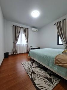 een slaapkamer met een bed en een houten vloer bij PS home โฮมฮักขอนแก่น in Ban Non Sa-at
