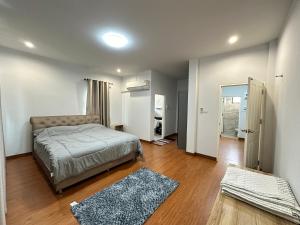 een slaapkamer met een bed en een hal met een deur bij PS home โฮมฮักขอนแก่น in Ban Non Sa-at