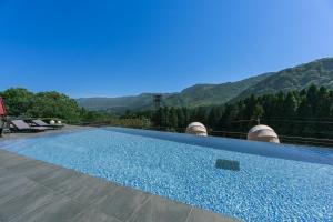 a swimming pool with a view of the mountains at The ACONCAGUA RESORTS in Minami Aso