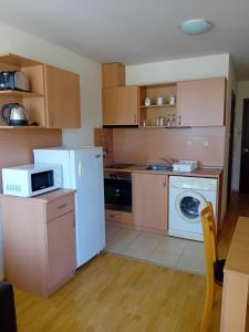 a kitchen with a white refrigerator and a dishwasher at Panorama Vigo Nesebar in Nesebar