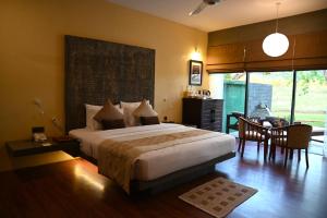 a bedroom with a large bed and a dining room at Sigiriya King's Resort in Sigiriya