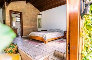 ein Schlafzimmer mit einem Bett in einem Zimmer in der Unterkunft Pouso da Lua in São Bento do Sapucaí