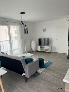 ein Wohnzimmer mit Sofa und Tisch in der Unterkunft Appartement F3 cozy avec balcon proche de Paris et aéroport CDG in Villiers-le-Bel + 26 Fotos