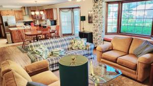 a living room with two couches and a kitchen at Entire Home in Golf Community - 5 Furnished Bedrooms in Fort Wayne