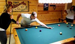 a man and a woman playing a game of pool at Entire Home in Golf Community - 5 Furnished Bedrooms in Fort Wayne