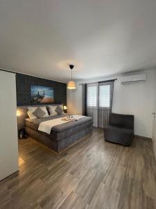 a large bedroom with a bed and a chair at Luxury by Villa Korina in Stankovci