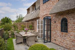 un patio avec une table et des chaises devant un bâtiment en briques dans l'établissement Gardenlodge 2, à List auf Sylt