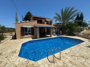 a villa with a swimming pool in front of a house at Villa Kalisorate in Tsadha