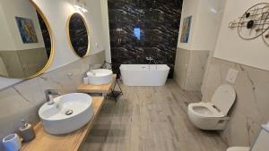 a bathroom with a sink and a toilet and mirrors at Village Gals in Đenovići